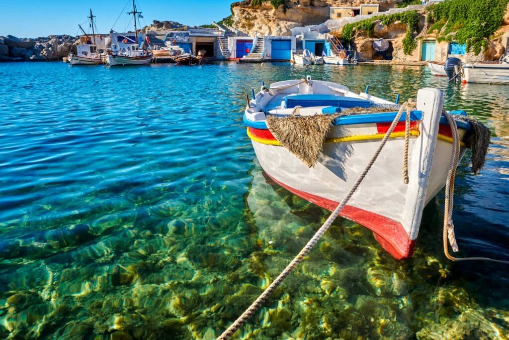 The fishing village of Mandrakia Milos with colourful boathouses and waterfront restaurant tables